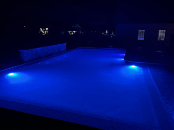 Luxury inground pool with custom LED lighting at night